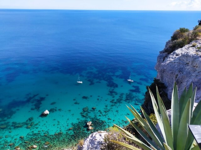 Nell'immagine, una vista panoramica del mare della Sardegna dall'alto di un promontorio.