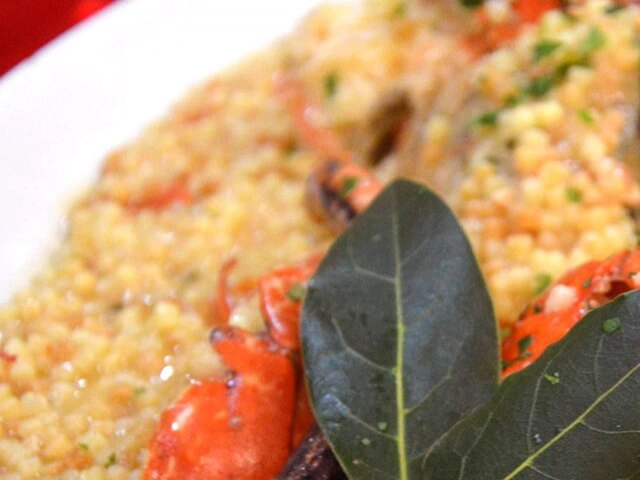 Nell'immagine, il primo piano su un piatto di fregola con dei crostacei.